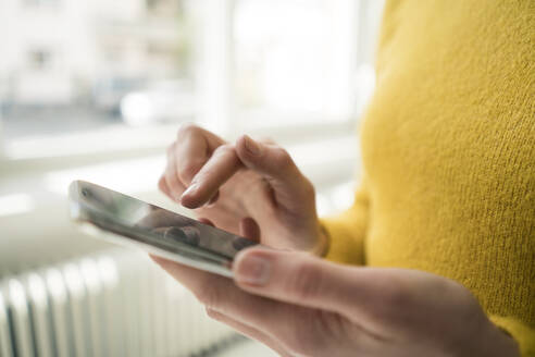 Frau im gelben Pullover, mit Smartphone - JOSF03411