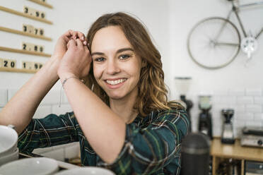 Proud young woman working in her own coffee shop - JOSF03427