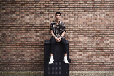 Portrait of young man in front of brick wall - IGGF01203