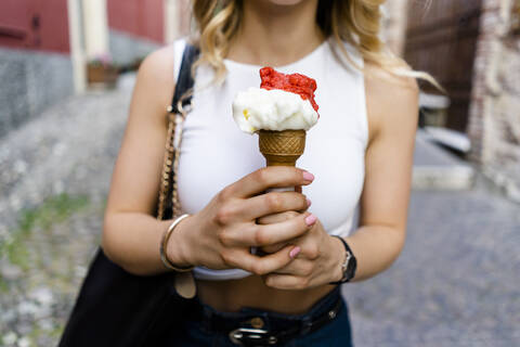 Hands of young woman holding ice cream cone stock photo