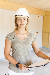 Portrait of a confident young woman in a new wooden house - TCF06134
