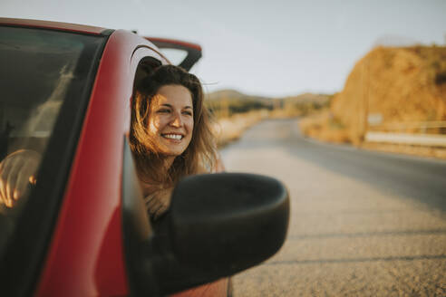 Woman on a road trip looking out of car window - DMGF00078