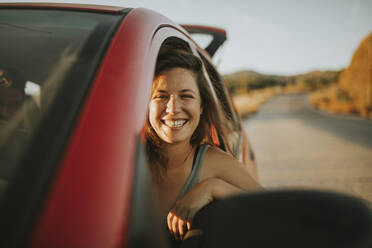 Frau auf einer Autoreise schaut aus dem Autofenster - DMGF00080