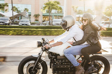 Couple riding motorbike in the city - LJF00296