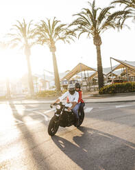 Couple riding on motorbike at evening twilight - LJF00307