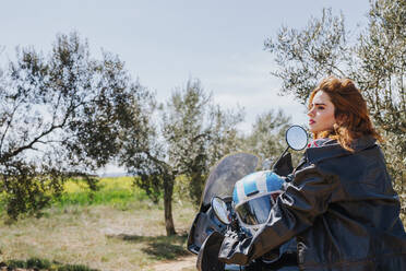 Redheaded woman on motorbike taking a rest, Andalusia, Spain - LJF00332