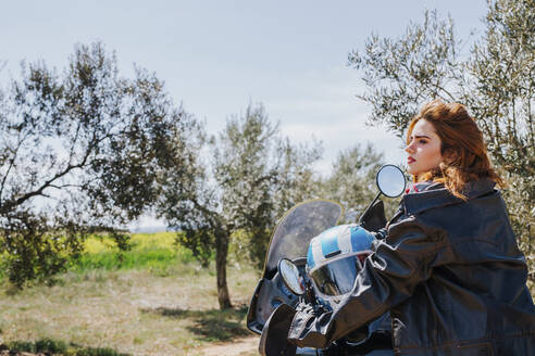 Rothaarige Frau auf einem Motorrad macht eine Pause, Andalusien, Spanien - LJF00332