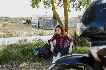 Motorcyclist having cigarette break under a tree - LJF00348