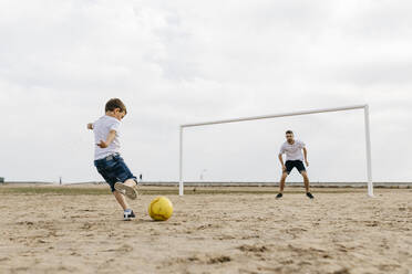 Mann und Junge spielen Fußball am Strand - JRFF03412