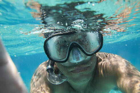 Porträt eines Mannes mit Taucherbrille und Schnorchel, der ein Selfie unter Wasser macht - IGGF01259