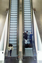 Young business people on an escalator - JSRF00376