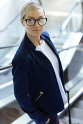 Portrait of a confident businesswoman on an escalator - JSRF00378