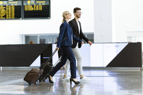 Two young business partners walking at the airport stock photo