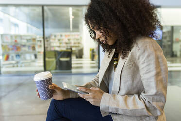 Junge Geschäftsfrau mit Kaffee zum Mitnehmen und Tablet - JSRF00410