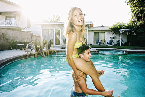 Couple playing in swimming pool stock photo