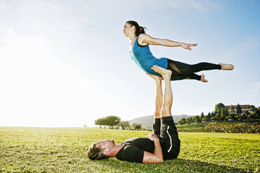 Kaukasisches Paar macht Acro-Yoga im Park - BLEF08270