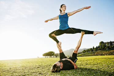 Kaukasisches Paar macht Acro-Yoga im Park - BLEF08271