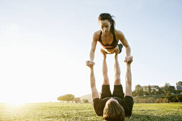 Kaukasisches Paar macht Acro-Yoga im Park - BLEF08272