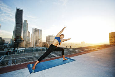 Mixed race woman practicing yoga on urban rooftop - BLEF08280