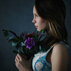 Caucasian teenage girl holding bouquet of flowers - BLEF08299