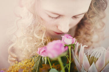 Caucasian teenage girl smelling bouquet of flowers - BLEF08300