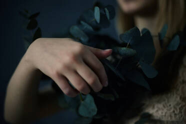 Caucasian teenage girl holding plants - BLEF08303