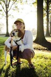 Kaukasische Frau umarmt Hund im Park - BLEF08318