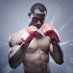 Back lit African boxer with arms raised - BLEF08332