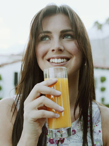 Frau trinkt Orangensaft, lizenzfreies Stockfoto