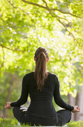 Caucasian woman practicing yoga in park - BLEF08468