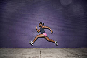 Female athlete running on sidewalk - BLEF08493