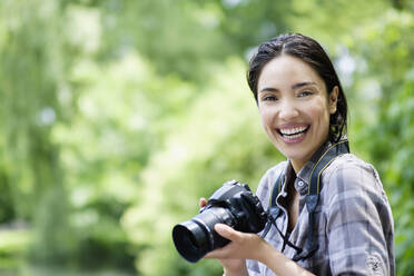 Hispanische Frau beim Fotografieren im Freien - BLEF08532