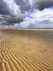 Belgien, Flandern, Nordseeküste, Sturmwolken über gekräuseltem Strandsand - GWF06130