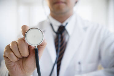 Close up of mixed race doctor holding stethoscope - BLEF08572