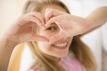 Caucasian girl making heart shape with hands - BLEF08624