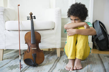 Wütender Junge gemischter Rasse weigert sich, Geige zu üben - BLEF08633
