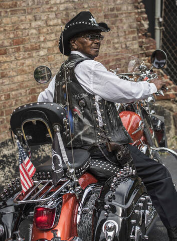 Älterer afroamerikanischer Mann fährt Motorrad, lizenzfreies Stockfoto