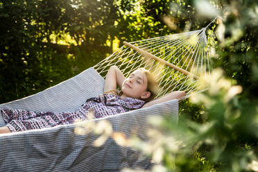 Germany, Bavaria, Landshut, Girl relaxing in hammock in garden - SARF04323