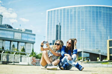 Women taking picture on city street - BLEF08670