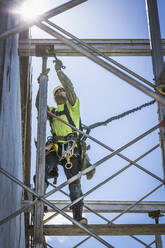 Caucasian worker on scaffolding on construction site - BLEF08678