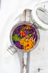 Jar of red cabbage, chili peppers, carrots and coriander on wooden table - LVF08119