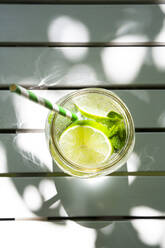 Ein Glas Limetten-Minz-Limonade auf dem Gartentisch - LVF08122