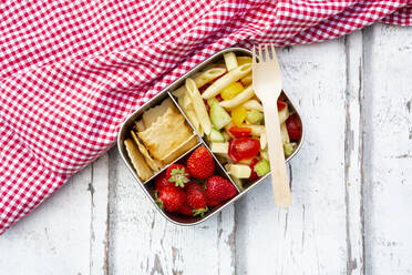 Pasta salad, strawberries and crackers in lunch box on wooden table - LVF08125