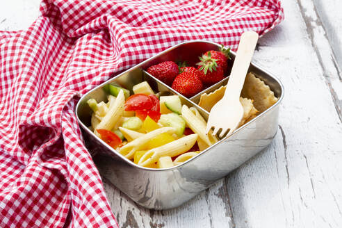 Nudelsalat, Erdbeeren und Cracker in der Lunchbox auf dem Holztisch - LVF08127