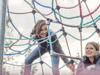 Portrait of two friends on jungle gym - LAF02345