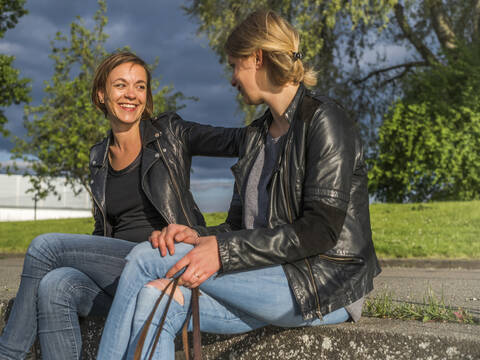 Deutschland, zwei junge Frauen, zwei Freundinnen, im Dialog, lizenzfreies Stockfoto