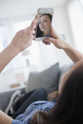 Woman taking selfie on sofa - BLEF08712