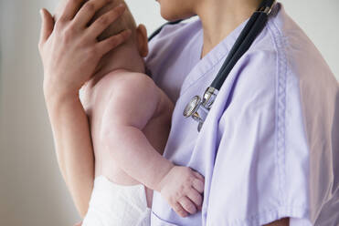 Nurse holding baby in hospital - BLEF08718