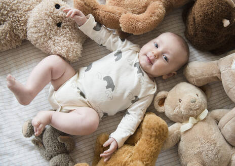 Kaukasische Baby-Stofftiere auf dem Bett - BLEF08719