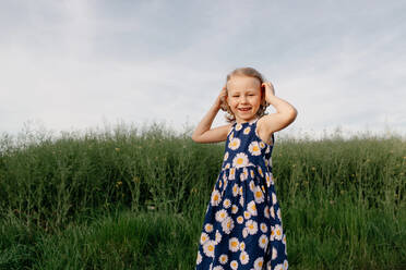 Porträt eines glücklichen kleinen Mädchens im Sommerkleid mit Blumenmuster - OGF00011